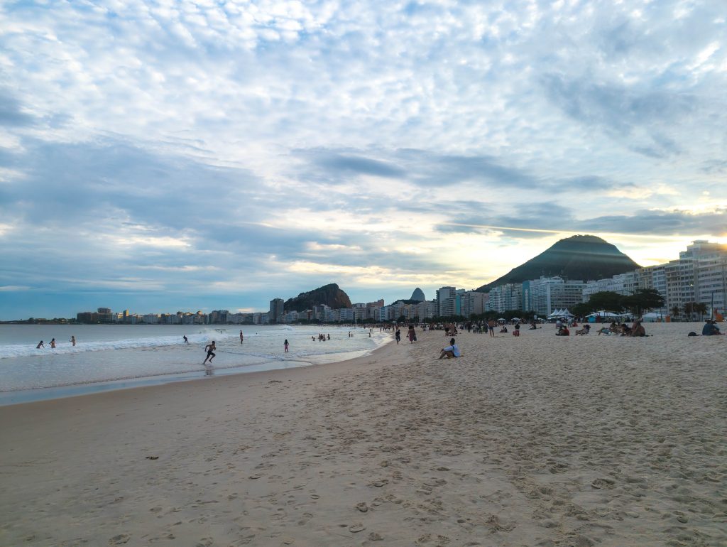 Copacabana beachfront promenade and breaking surf along the Atlantic shoreline at dusk