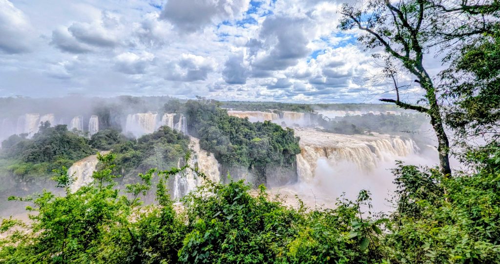 Water plunging over rocky basalt drops creating dense plumes of mist at Iguazu Falls