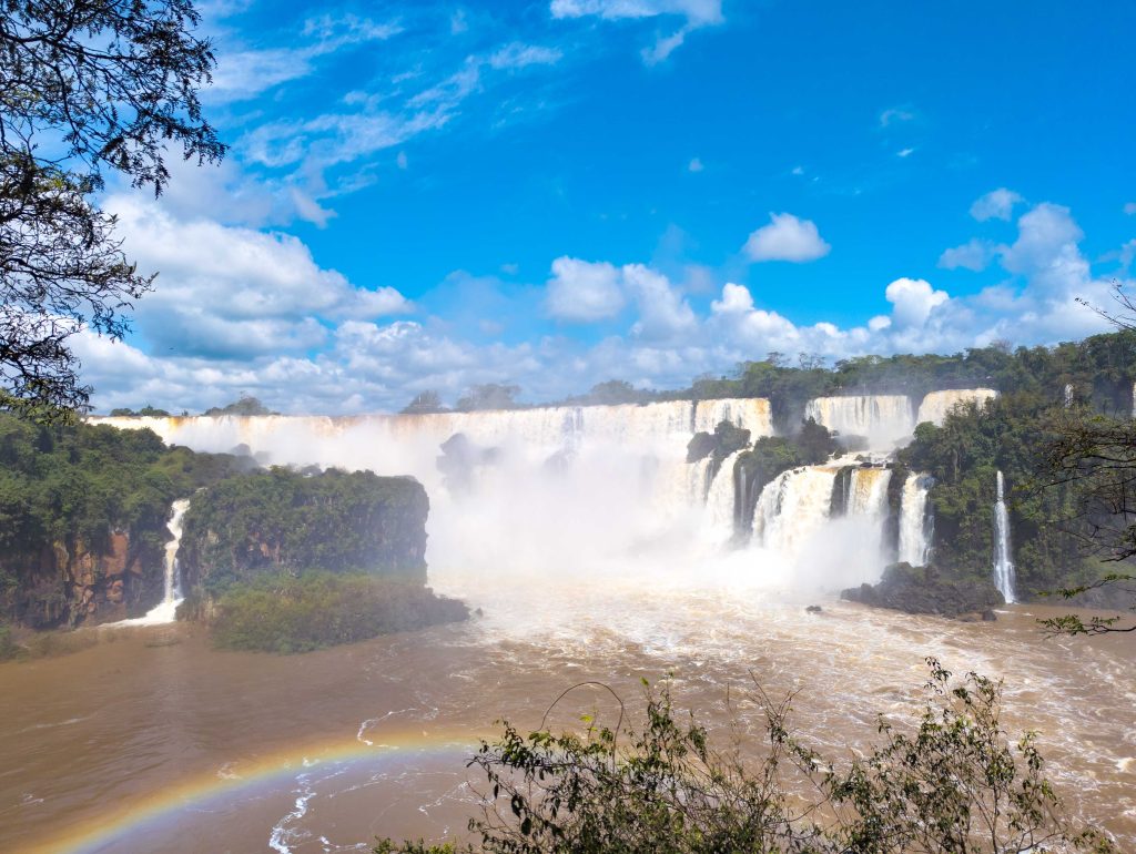 Vivid rainbow arcing across the spray of roaring waterfalls in the Argentine sector of Iguazu