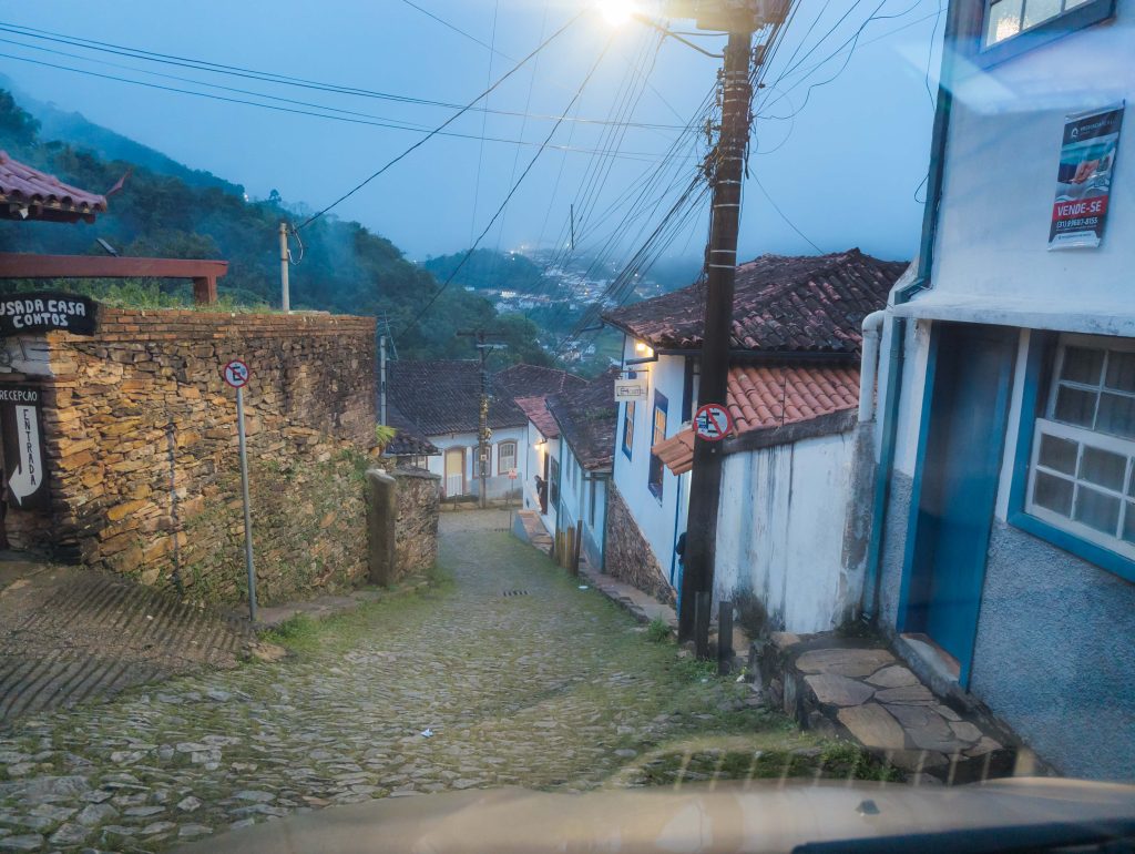 Steep cobblestone street paved with pe de moleque river stones in historic Ouro Preto