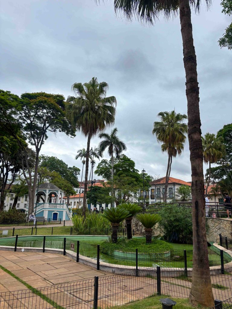 Public garden square with tall palm trees and an ornate blue gazebo bandstand in Petropolis