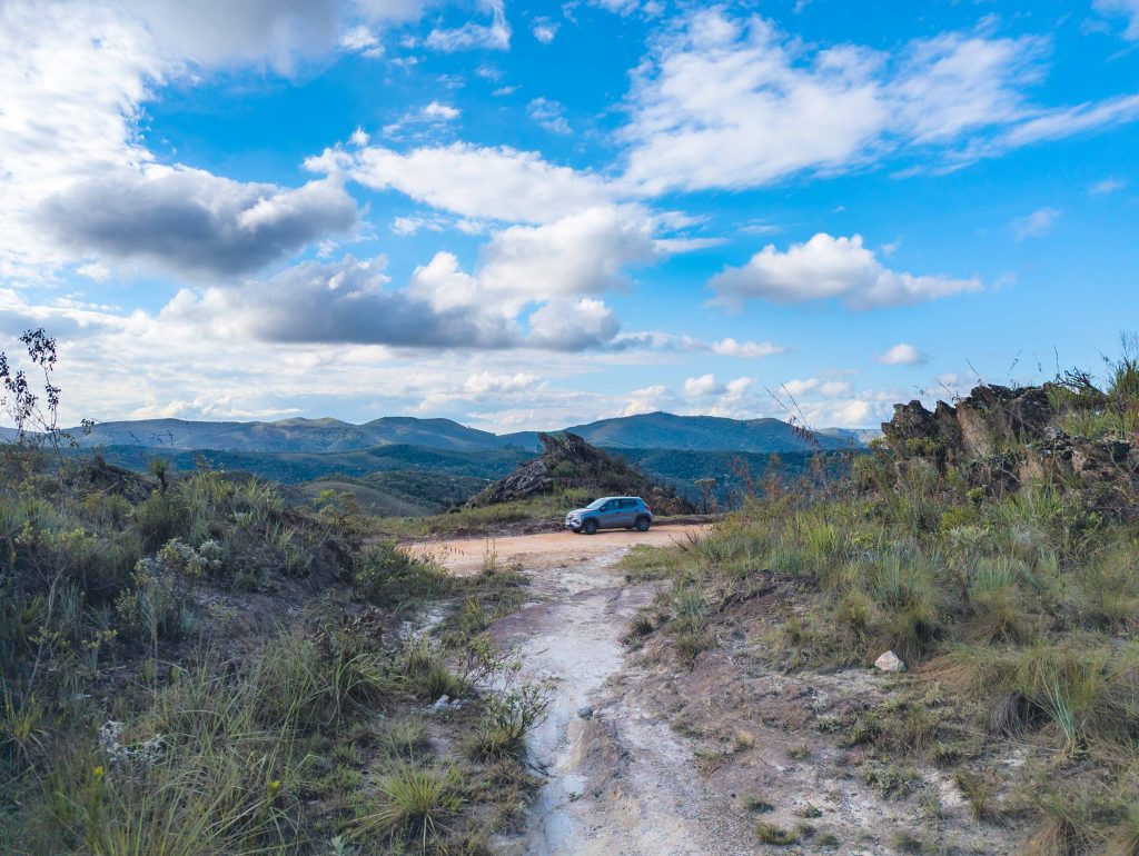 Silver flex fuel rental car parked along a scenic mountain ridge road in Minas Gerais