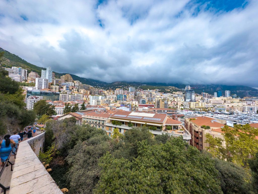 High trail overlook showing the skyscrapers and harbor of Monaco nestled along the Mediterranean coastline