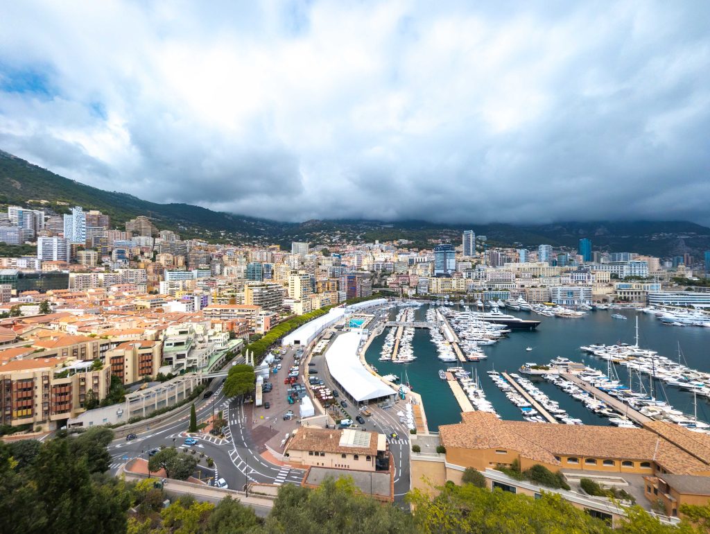Overlook of Port Hercule in Monaco showcasing mega yachts moored at the marina with event grandstands