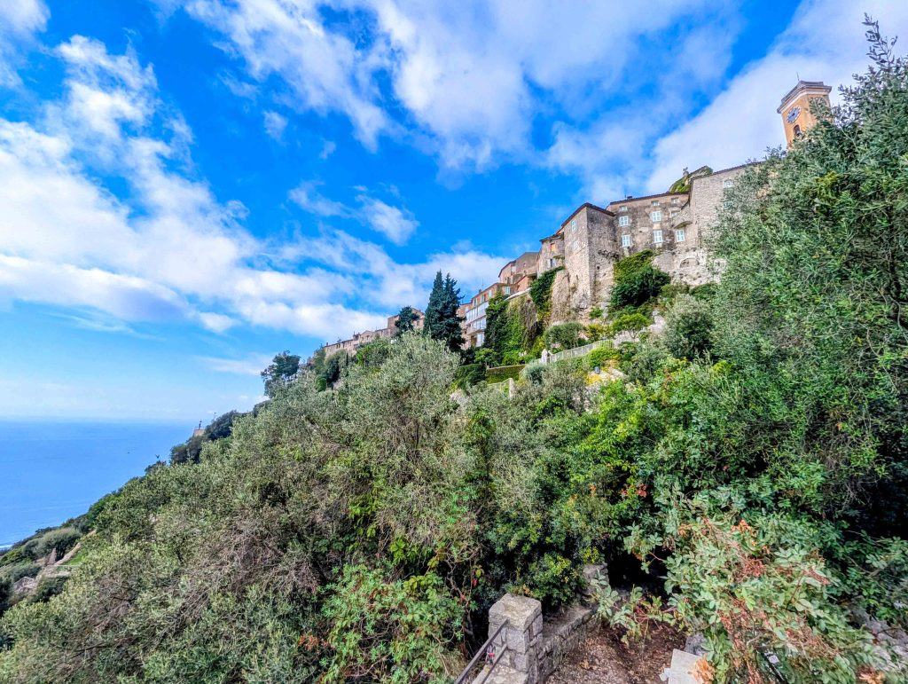 Medieval village of Eze perched atop rocky limestone cliffs with the church bell tower against the sky