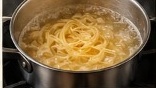 Fettuccine pasta boiling in pot of salted water